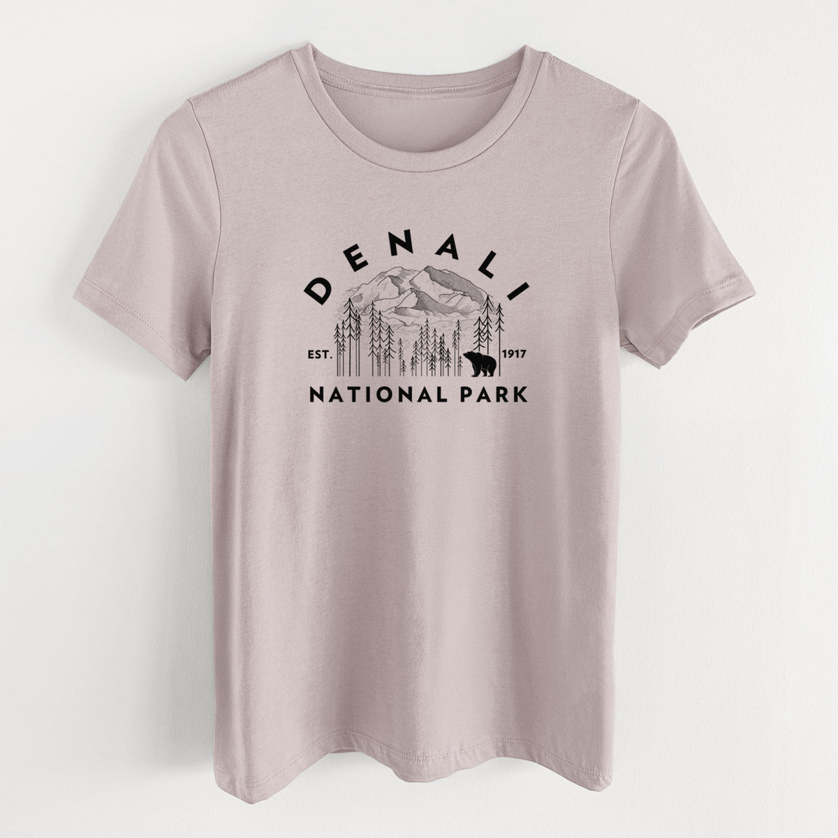 Pink gravel women's relaxed fit cotton t-shirt laid flat, printed with a round badge of mountains, pine trees and a bear, with the words Denali National Park, Est. 1917.