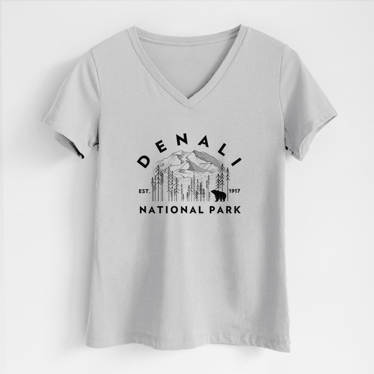 Lunar grey women's relaxed fit cotton V-neck t-shirt laid flat, printed with a round badge of mountains, pine trees and a bear, with the words Denali National Park, Est. 1917.
