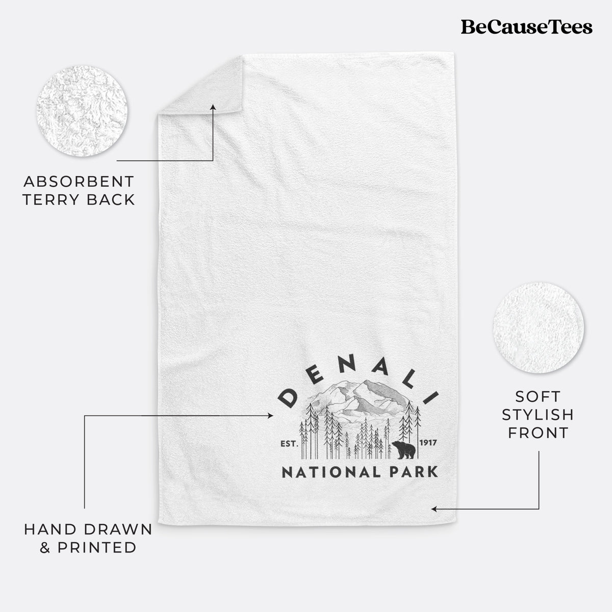 White hand towel printed with a round badge of mountains, pine trees and a bear, with the words Denali National Park, Est. 1917.