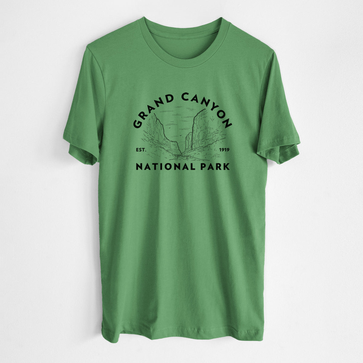 Leaf green lightweight cotton t-shirt laid flat, printed with a round badge of canyon cliffs, with the words Grand Canyon National Park, Est. 1919.