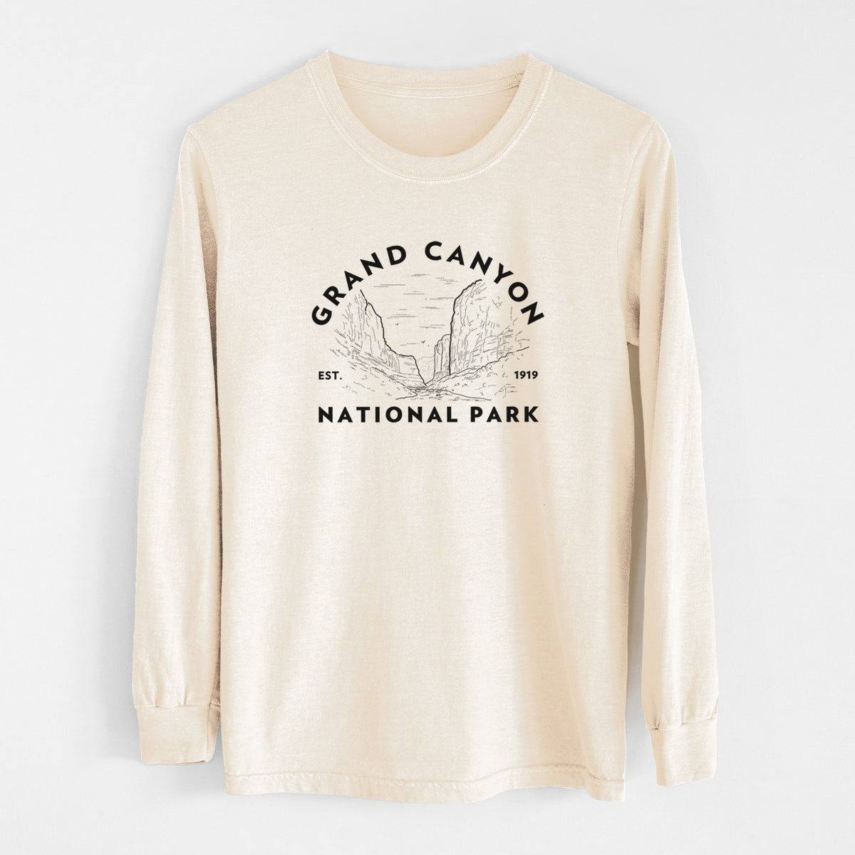 Ivory Comfort Colors long sleeve shirt laid flat, printed with a round badge of canyon cliffs, with the words Grand Canyon National Park, Est. 1919.