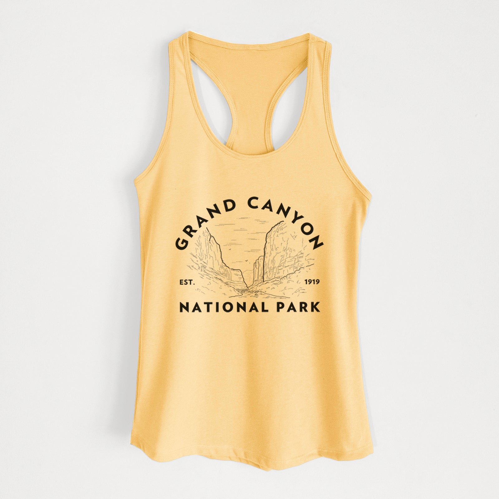Banana cream women's racerback tank top laid flat, printed with a round badge of canyon cliffs, with the words Grand Canyon National Park, Est. 1919.