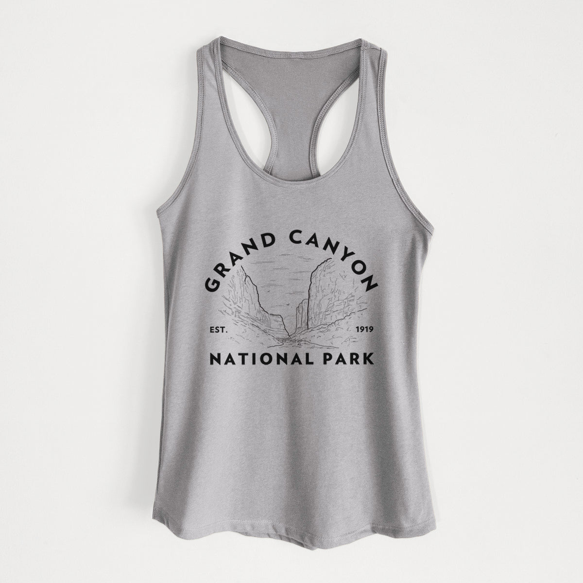 Heather grey women's racerback tank top laid flat, printed with a round badge of canyon cliffs, with the words Grand Canyon National Park, Est. 1919.