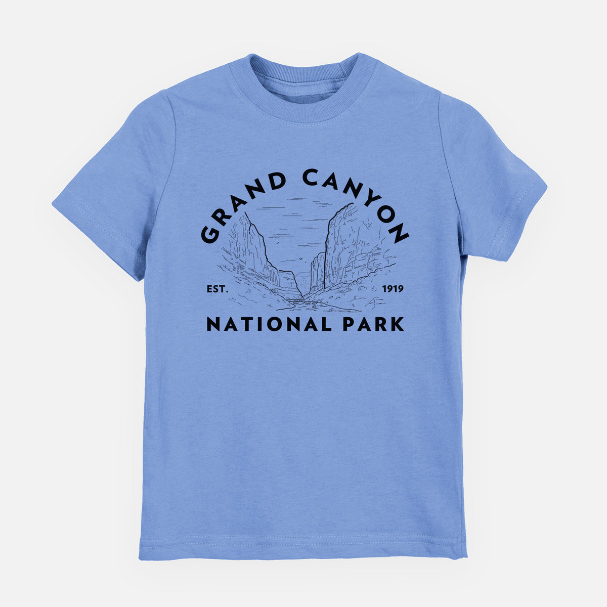 Carolina blue youth t-shirt laid flat, printed with a round badge of canyon cliffs, with the words Grand Canyon National Park, Est. 1919.