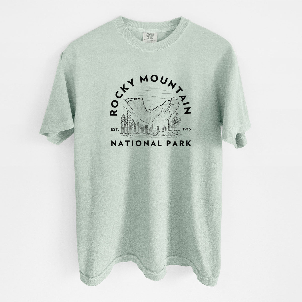 Bay green Comfort Colors t-shirt laid flat, printed with a round badge of mountains and pine trees, with the words Rocky Mountain National Park, Est. 1915.