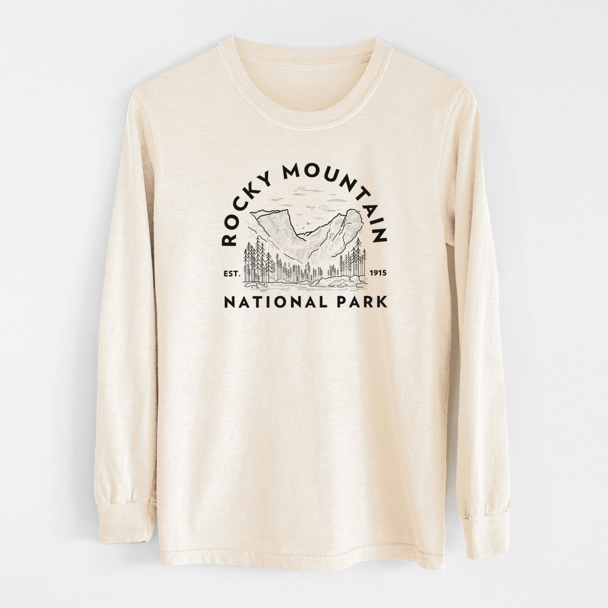 Ivory Comfort Colors long sleeve shirt laid flat, printed with a round badge of mountains and pine trees, with the words Rocky Mountain National Park, Est. 1915.