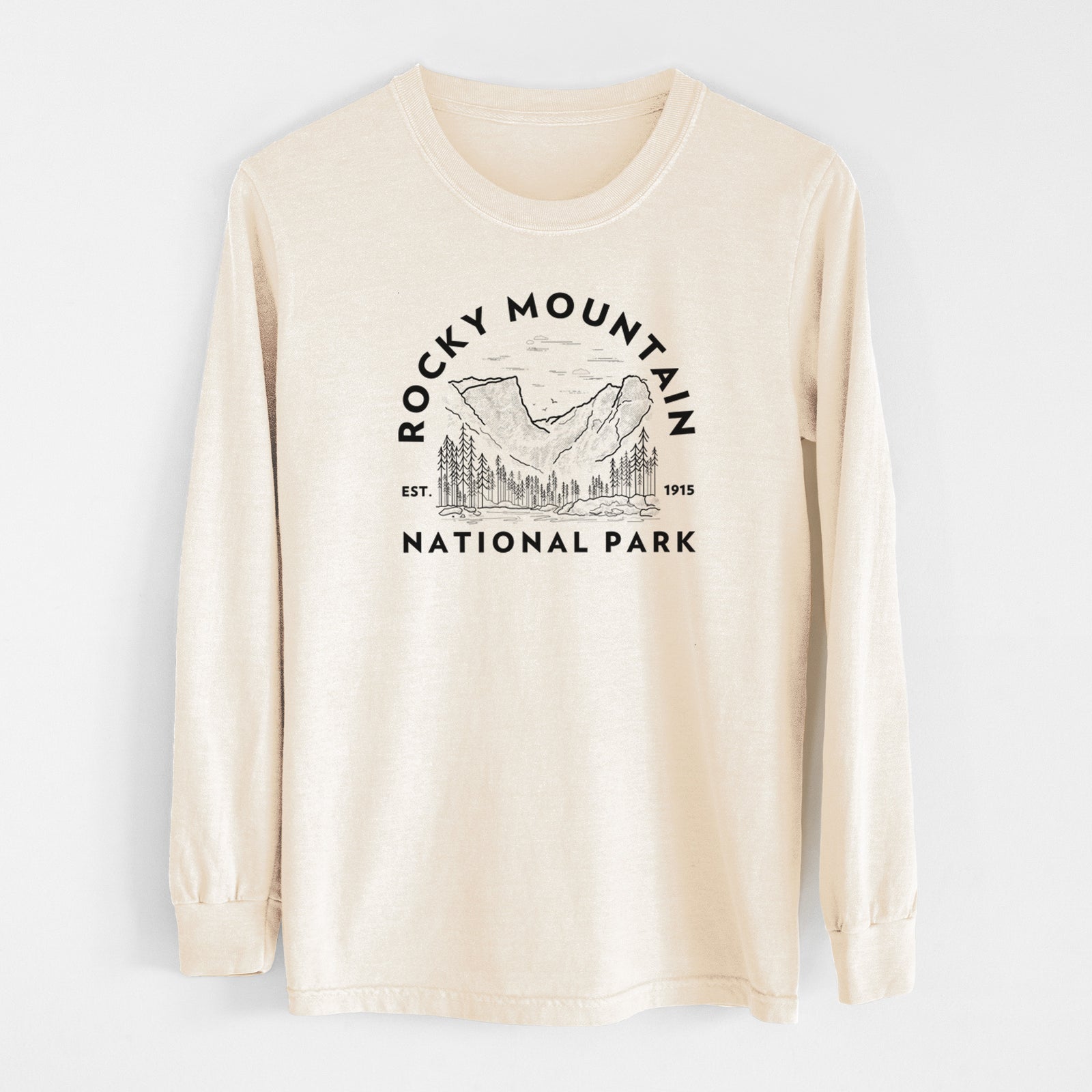 Ivory Comfort Colors long sleeve shirt laid flat, printed with a round badge of mountains and pine trees, with the words Rocky Mountain National Park, Est. 1915.