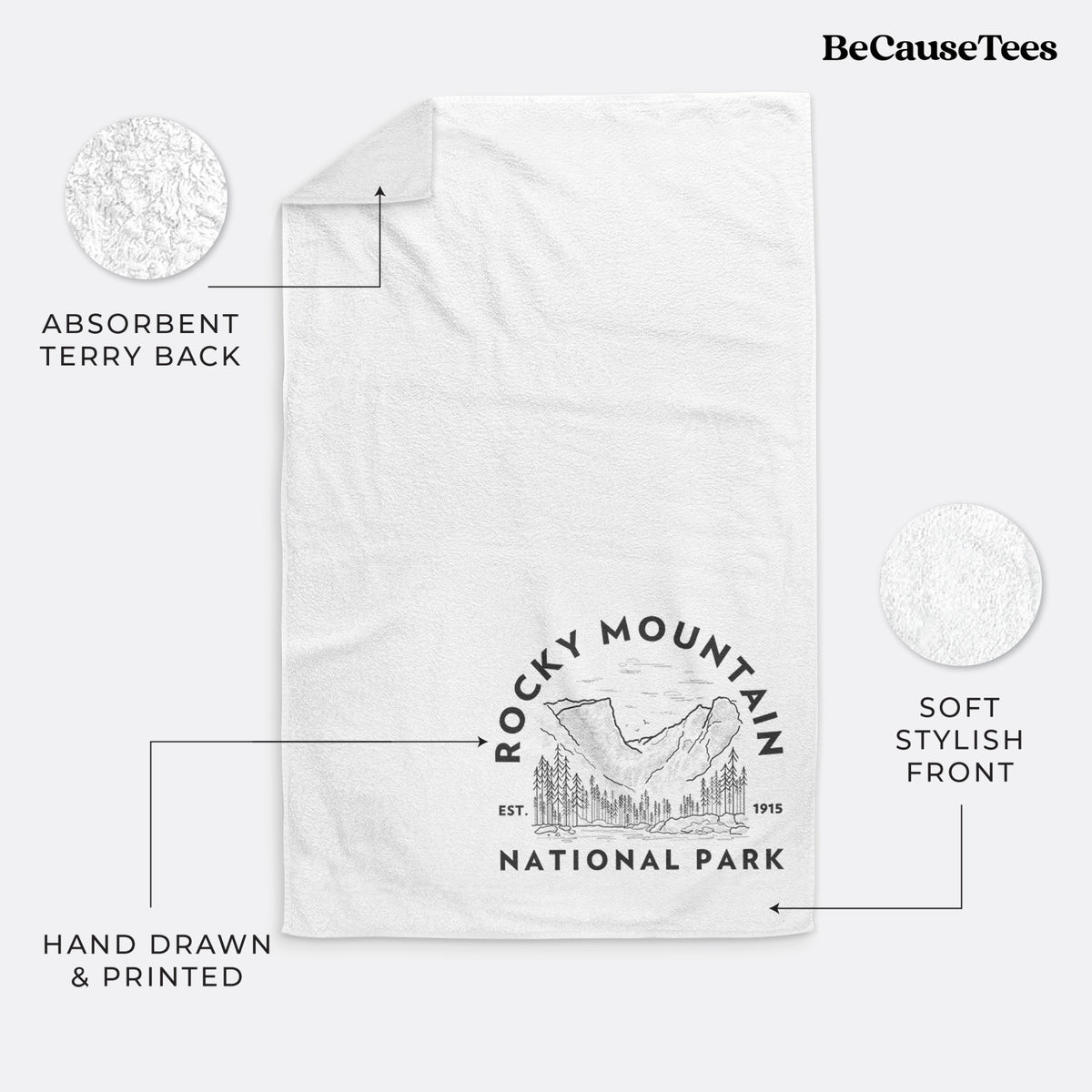 White hand towel printed with a round badge of mountains and pine trees, with the words Rocky Mountain National Park, Est. 1915.