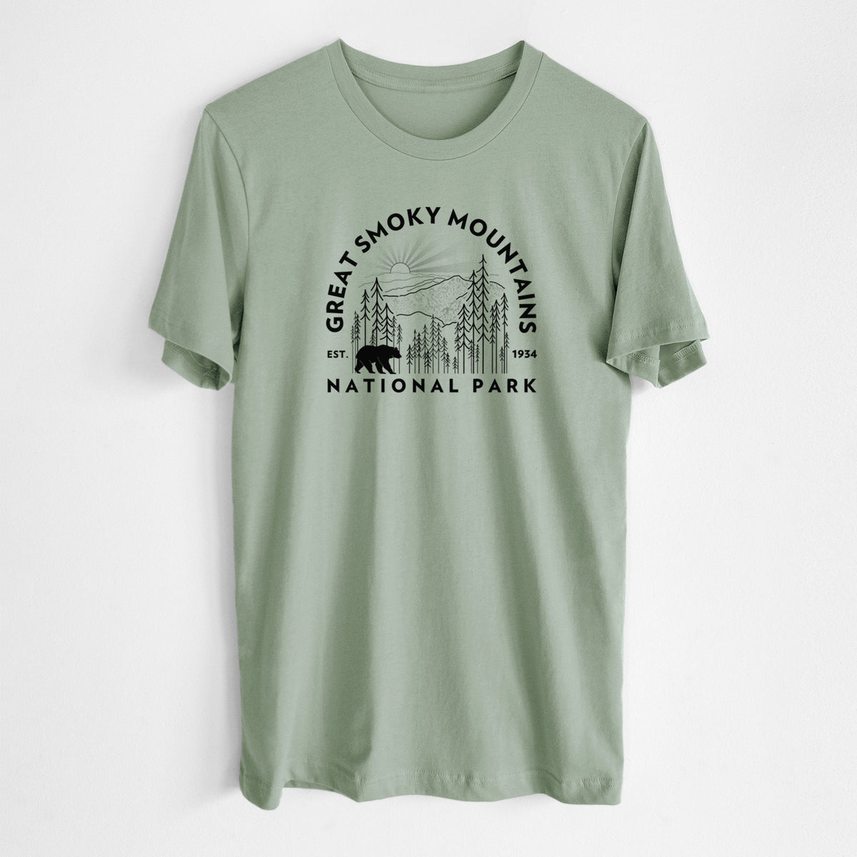 Sage green lightweight cotton t-shirt laid flat, printed with a round badge of mountains, pine trees and a black bear, with the words Great Smoky Mountains National Park, Est. 1934.