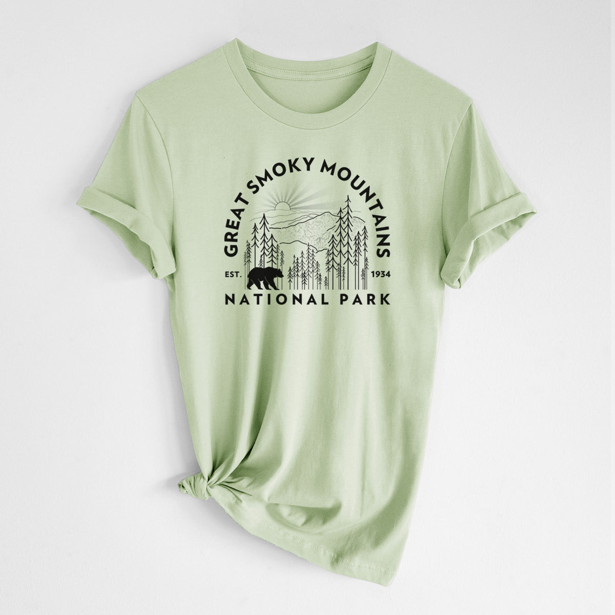 Spring green lightweight cotton t-shirt laid flat with the sleeves rolled, printed with a round badge of mountains, pine trees and a black bear, with the words Great Smoky Mountains National Park, Est. 1934.