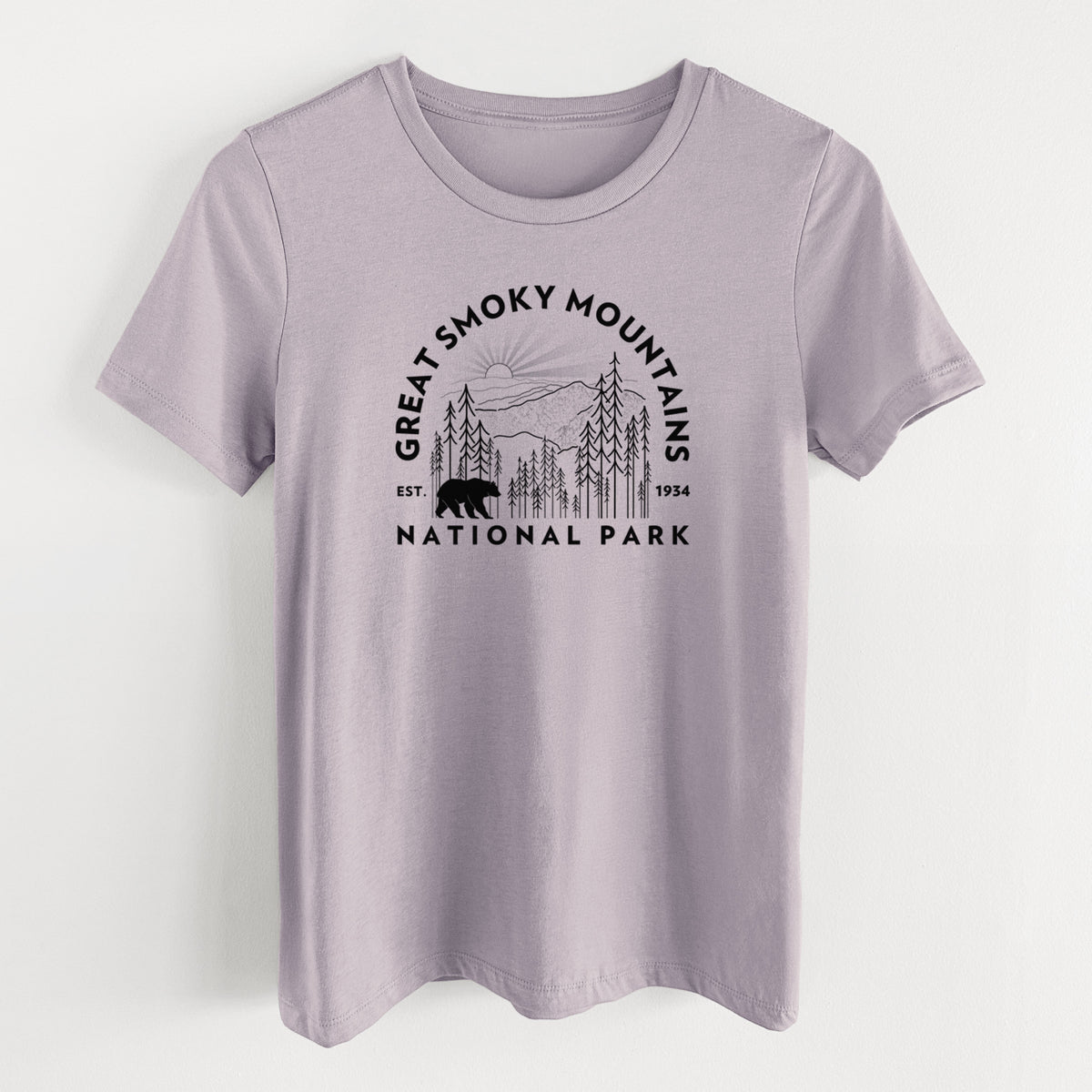 Light violet women's relaxed fit cotton t-shirt laid flat, printed with a round badge of mountains, pine trees and a black bear, with the words Great Smoky Mountains National Park, Est. 1934.