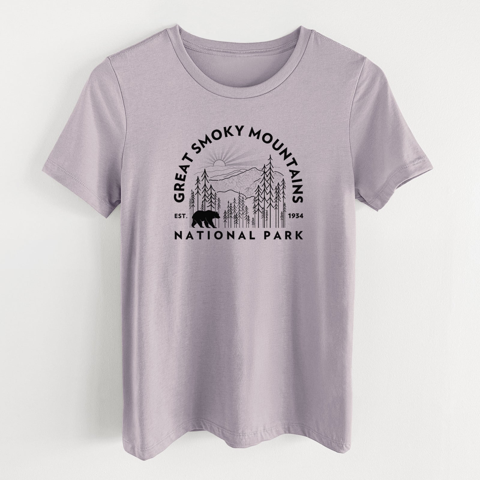 Light violet women's relaxed fit cotton t-shirt laid flat, printed with a round badge of mountains, pine trees and a black bear, with the words Great Smoky Mountains National Park, Est. 1934.