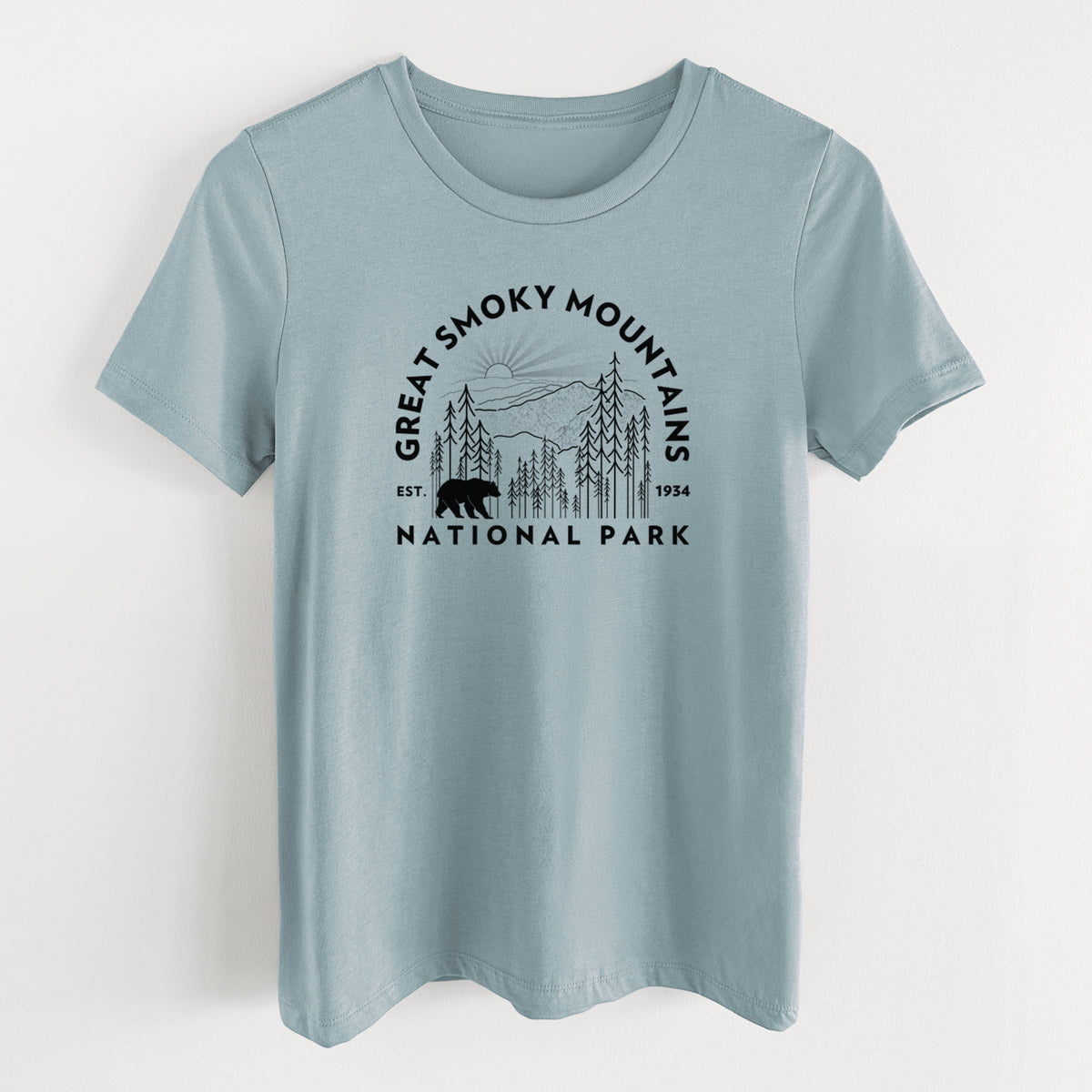 Vintage denim women's relaxed fit cotton t-shirt laid flat, printed with a round badge of mountains, pine trees and a black bear, with the words Great Smoky Mountains National Park, Est. 1934.