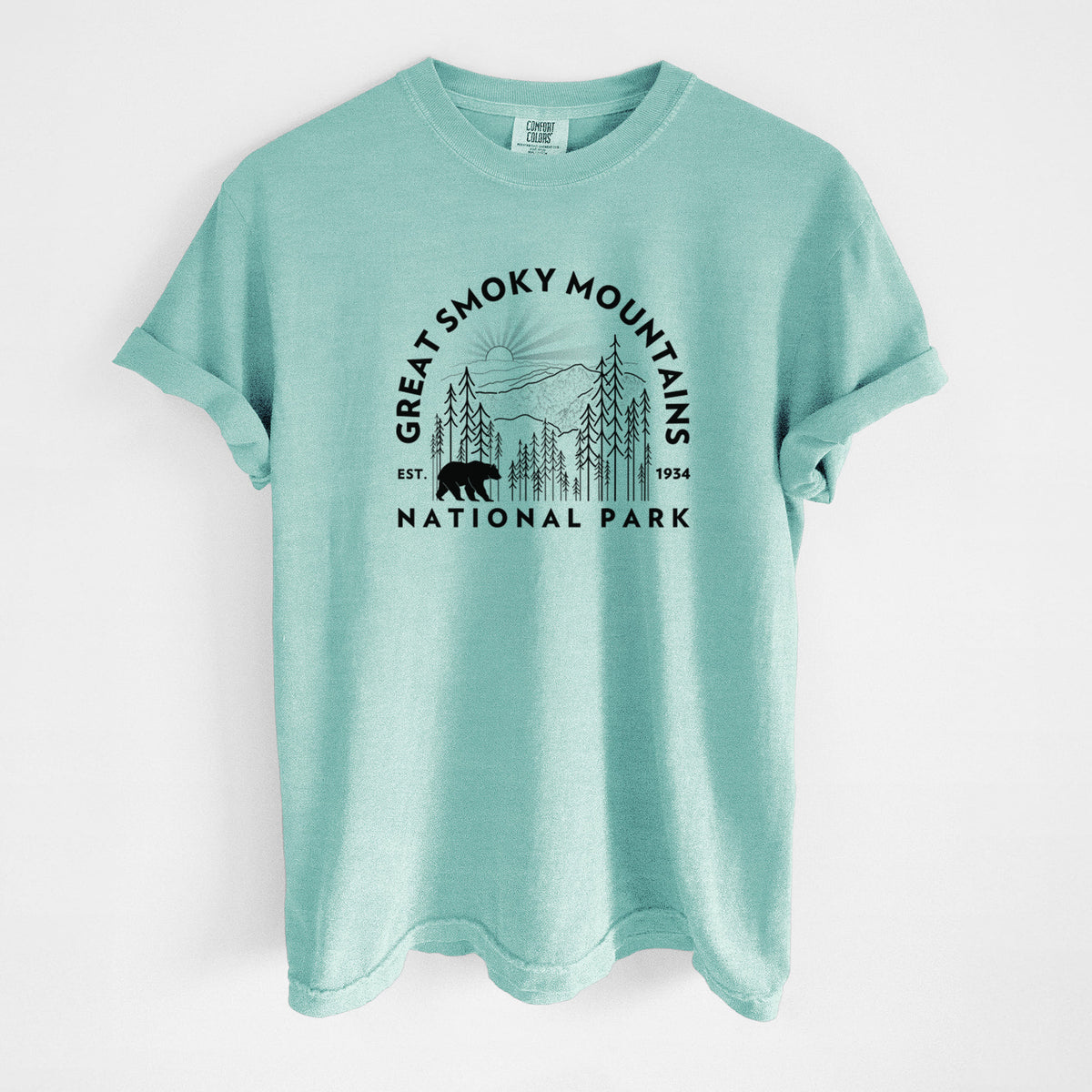 Chalky mint Comfort Colors t-shirt laid flat, printed with a round badge of mountains, pine trees and a black bear, with the words Great Smoky Mountains National Park, Est. 1934.