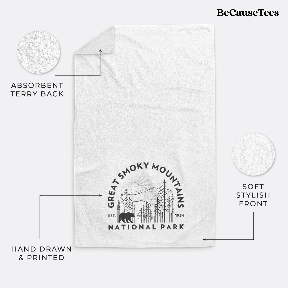 White hand towel printed with a round badge of mountains, pine trees and a black bear, with the words Great Smoky Mountains National Park, Est. 1934.
