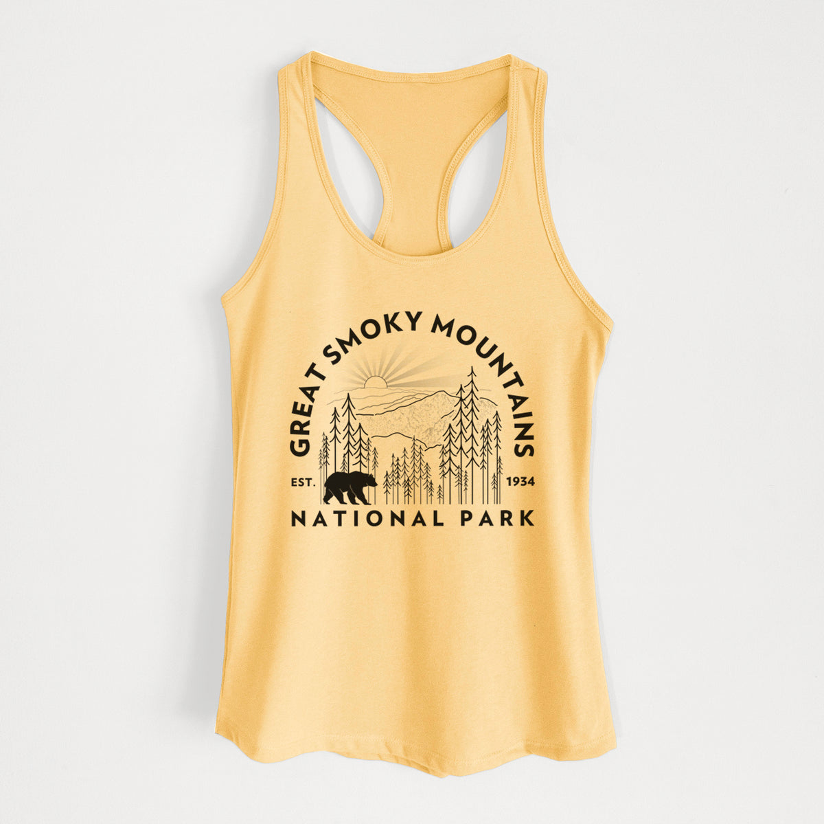 Banana cream women's racerback tank top laid flat, printed with a round badge of mountains, pine trees and a black bear, with the words Great Smoky Mountains National Park, Est. 1934.