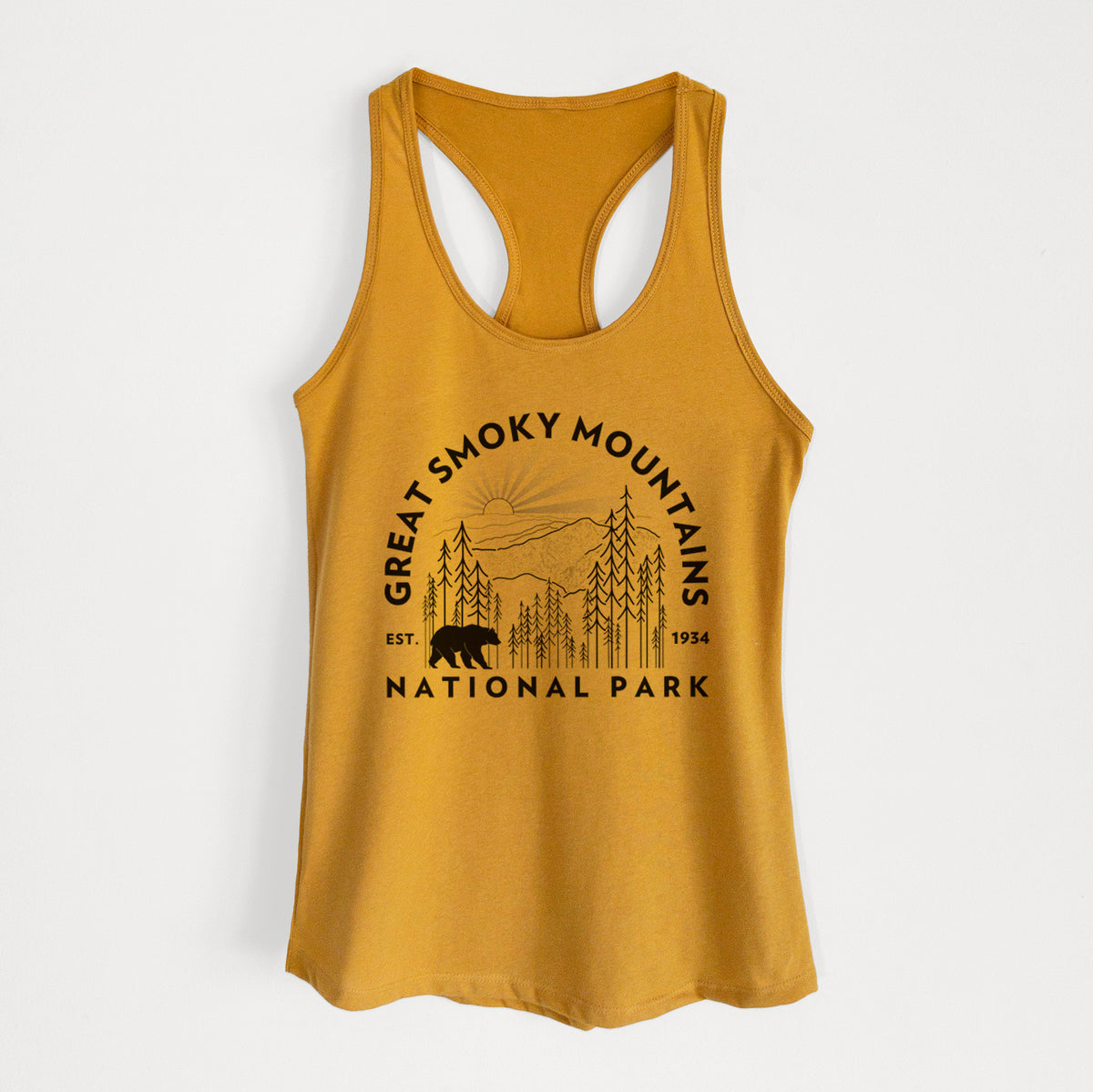 Gold women's racerback tank top laid flat, printed with a round badge of mountains, pine trees and a black bear, with the words Great Smoky Mountains National Park, Est. 1934.