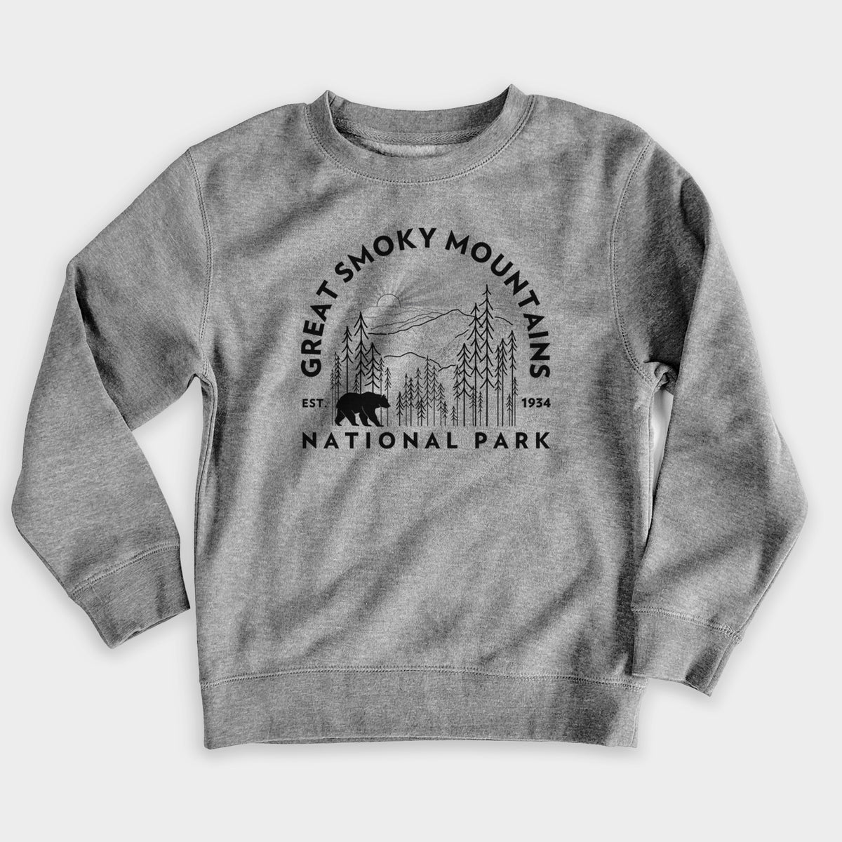 Nickel grey youth crewneck sweatshirt laid flat, printed with a round badge of mountains, pine trees and a black bear, with the words Great Smoky Mountains National Park, Est. 1934.
