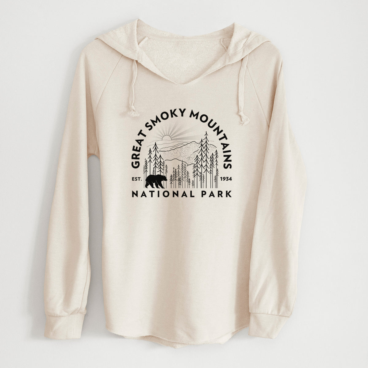 Bone cream women's Cali Wave hooded sweatshirt laid flat, printed with a round badge of mountains, pine trees and a black bear, with the words Great Smoky Mountains National Park, Est. 1934.