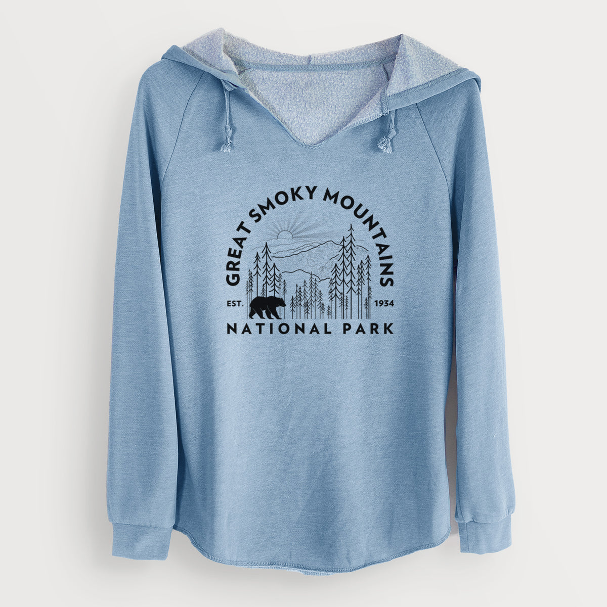 Misty blue women's Cali Wave hooded sweatshirt laid flat, printed with a round badge of mountains, pine trees and a black bear, with the words Great Smoky Mountains National Park, Est. 1934.