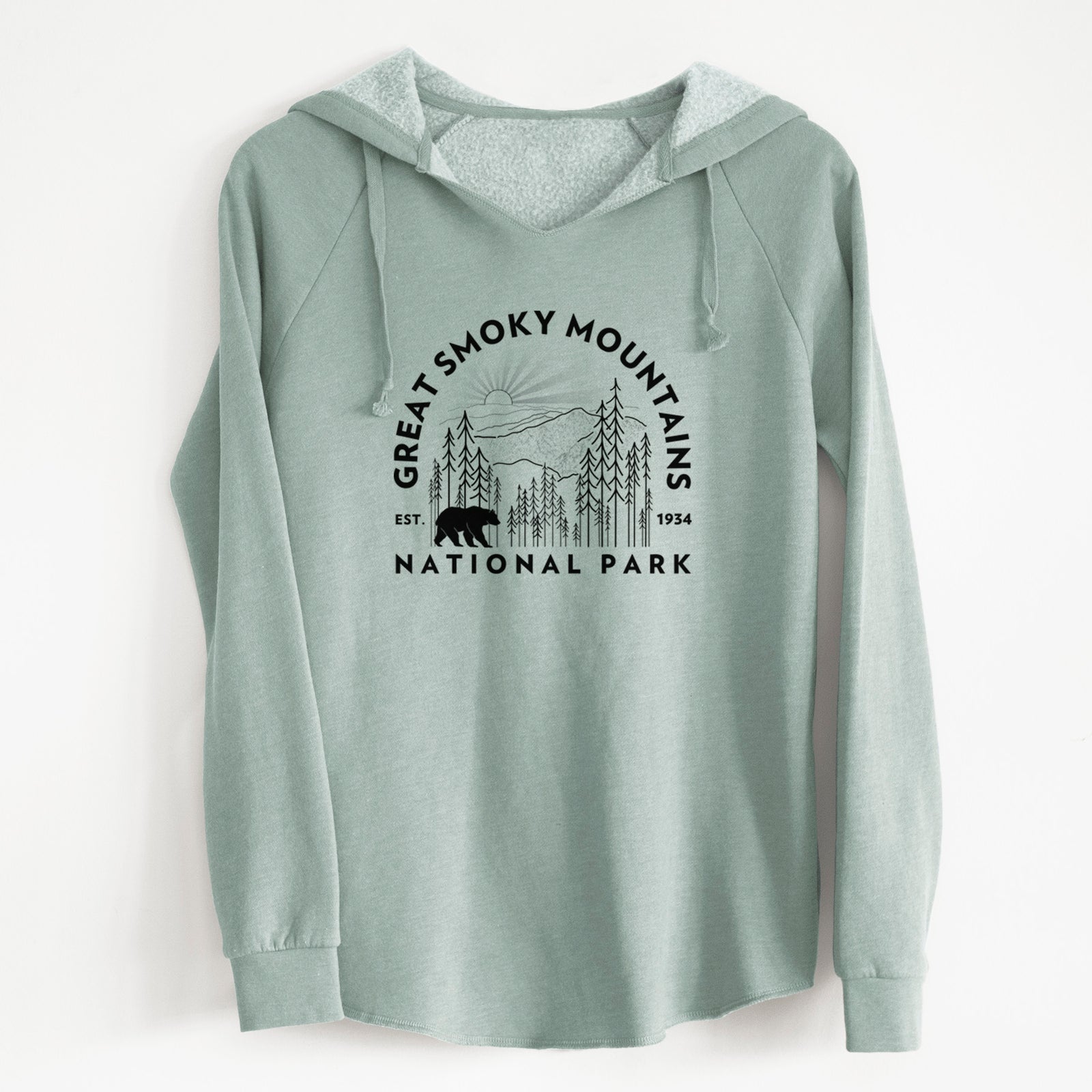 Sage green women's Cali Wave hooded sweatshirt laid flat, printed with a round badge of mountains, pine trees and a black bear, with the words Great Smoky Mountains National Park, Est. 1934.