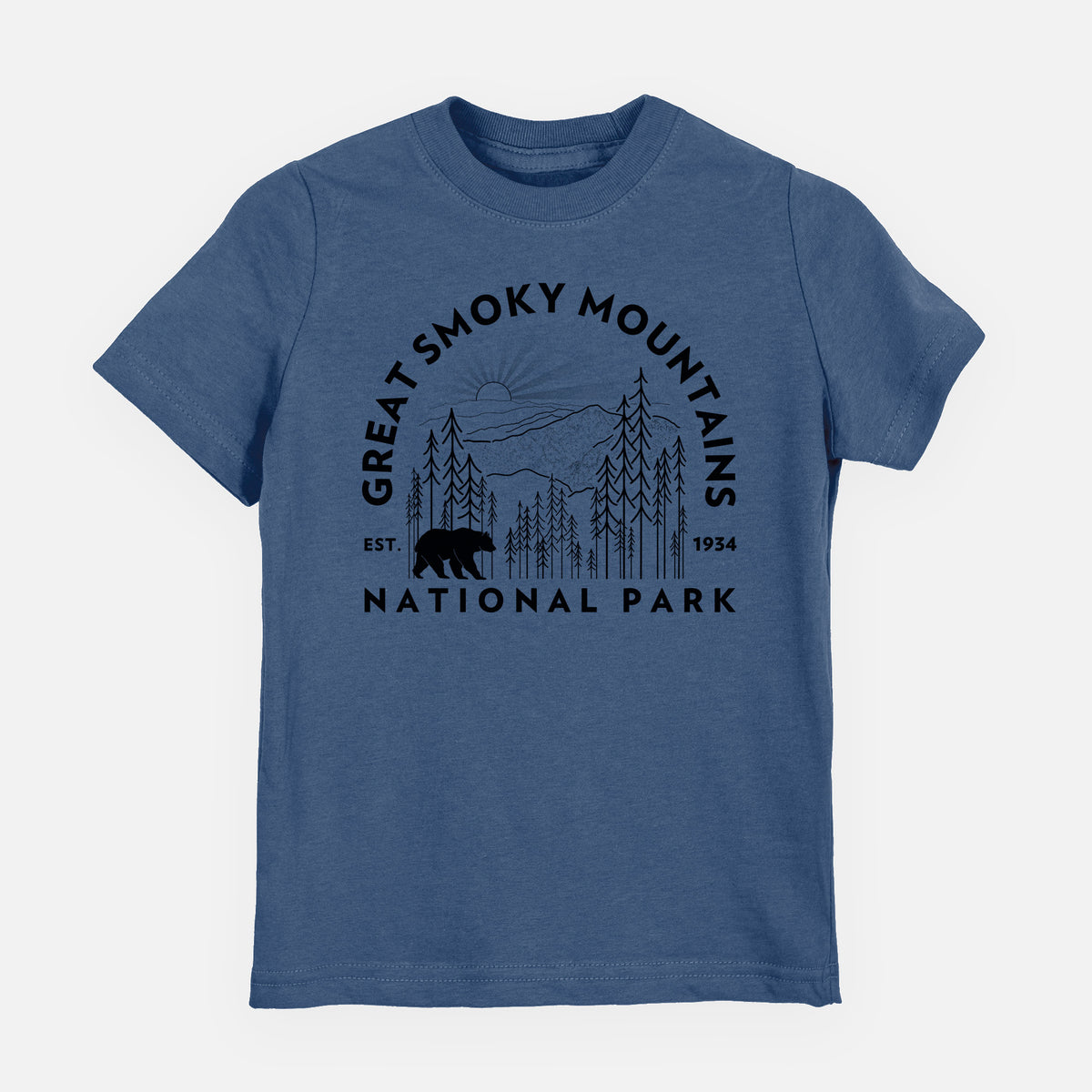 Indigo blue youth t-shirt laid flat, printed with a round badge of mountains, pine trees and a black bear, with the words Great Smoky Mountains National Park, Est. 1934.