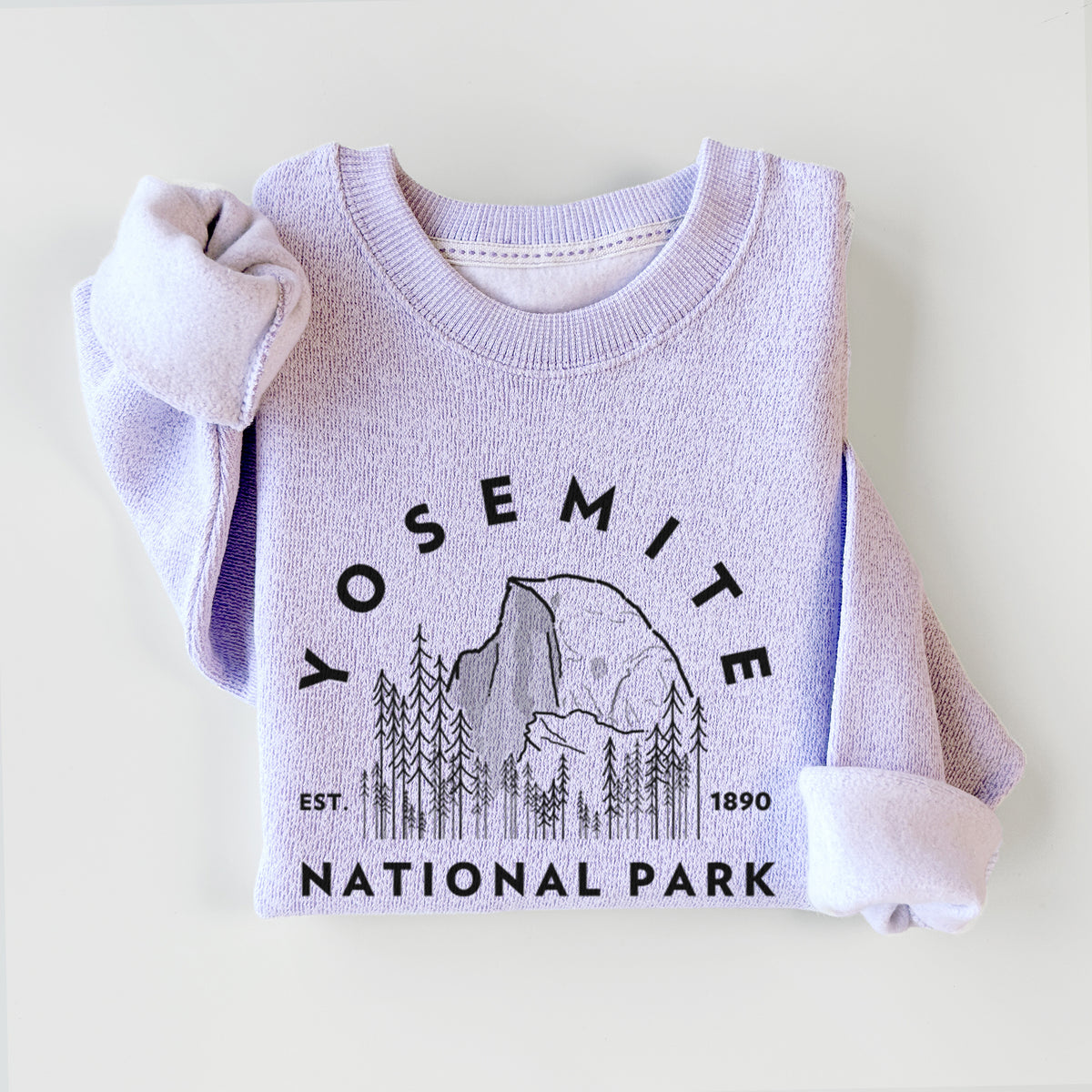 Ice purple knit sweatshirt printed with a round badge of Half Dome and pine trees, with the words Yosemite National Park, Est. 1890, styled flat.