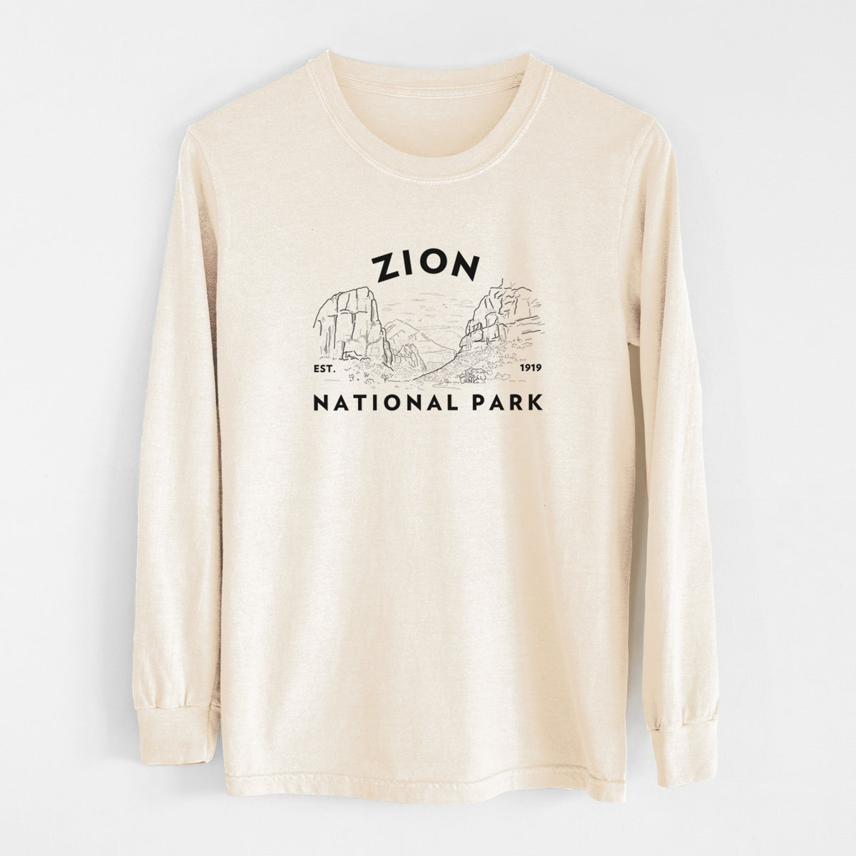 Ivory Comfort Colors long sleeve shirt laid flat, printed with a round badge of canyon walls, with the words Zion National Park, Est. 1919.