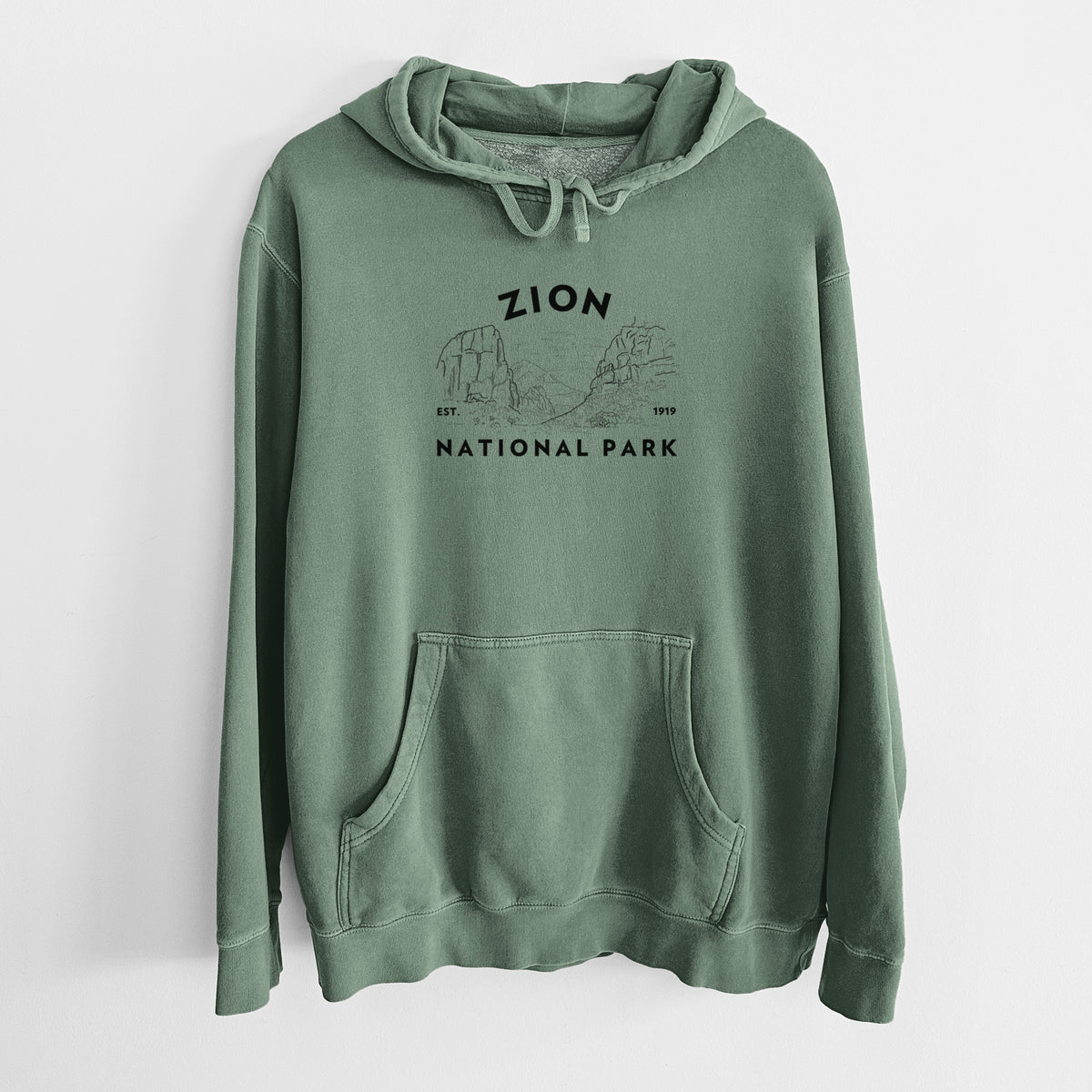 Alpine green pigment dyed hoodie laid flat, printed with a round badge of canyon walls, with the words Zion National Park, Est. 1919.