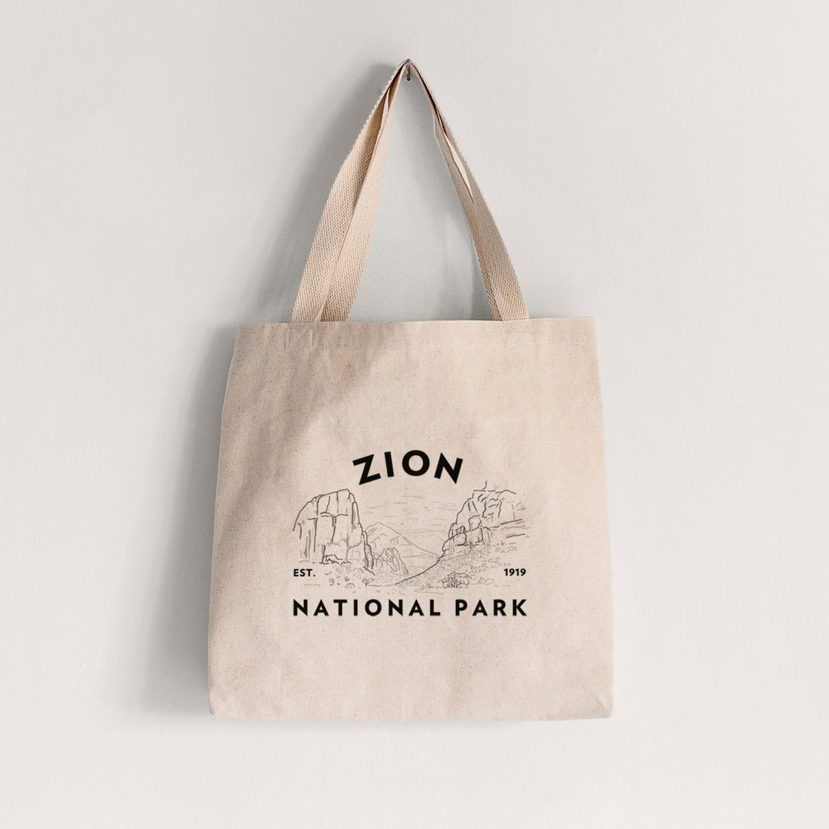 Natural canvas tote bag printed with a round badge of canyon walls, with the words Zion National Park, Est. 1919.