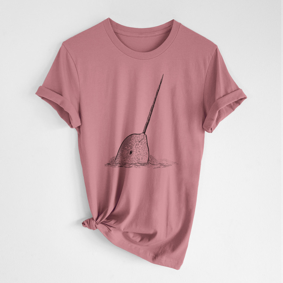 Mauve pink lightweight cotton t-shirt laid flat with the sleeves rolled, printed with a black ink illustration of a narwhal with its long spiral tusk pointing upward.
