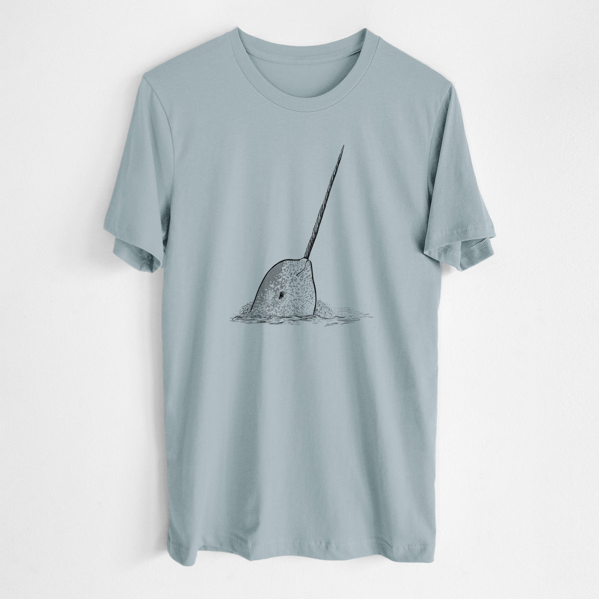 Vintage denim lightweight cotton t-shirt laid flat, printed with a black ink illustration of a narwhal with its long spiral tusk pointing upward.