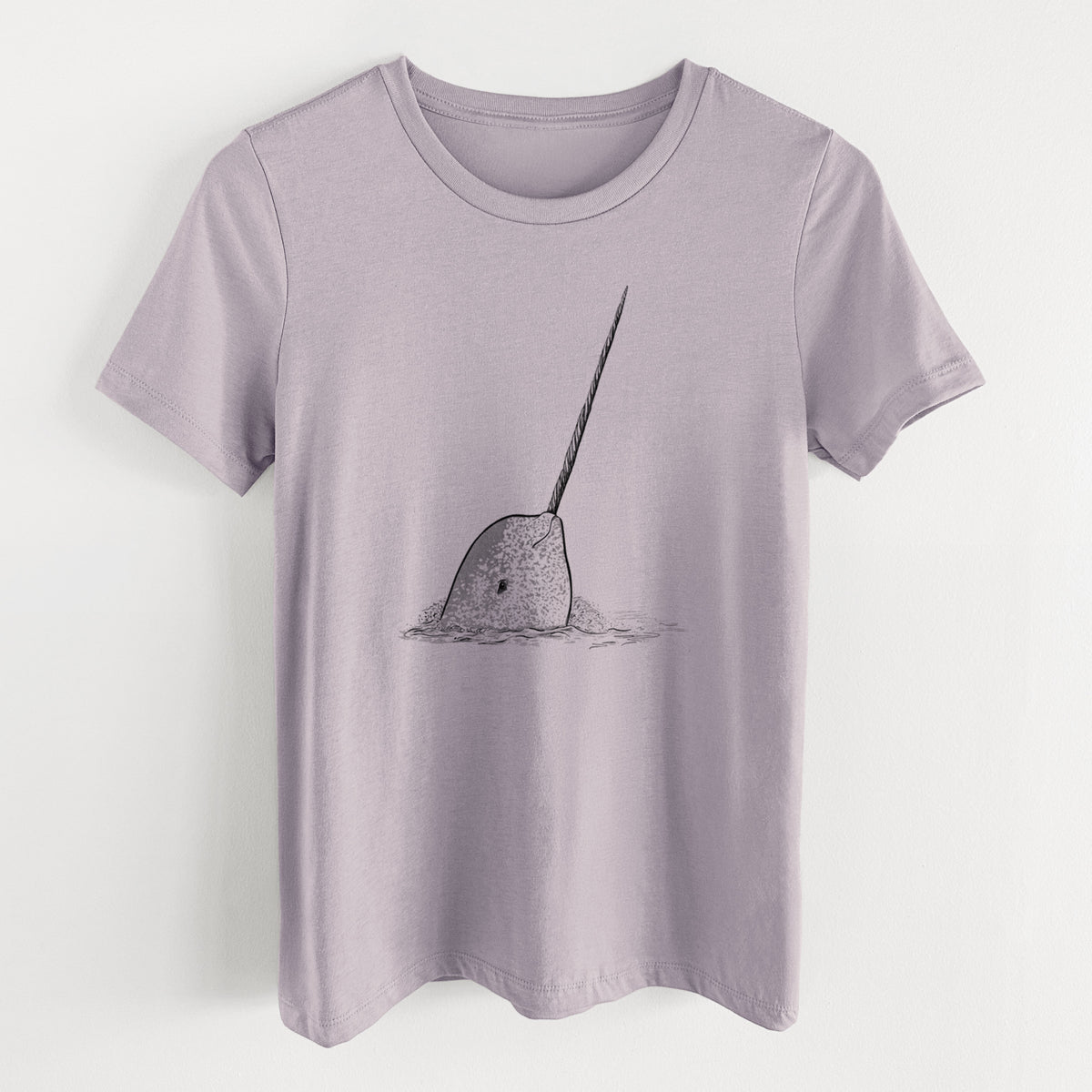 Light violet women's relaxed fit cotton t-shirt laid flat, printed with a black ink illustration of a narwhal with its long spiral tusk pointing upward.