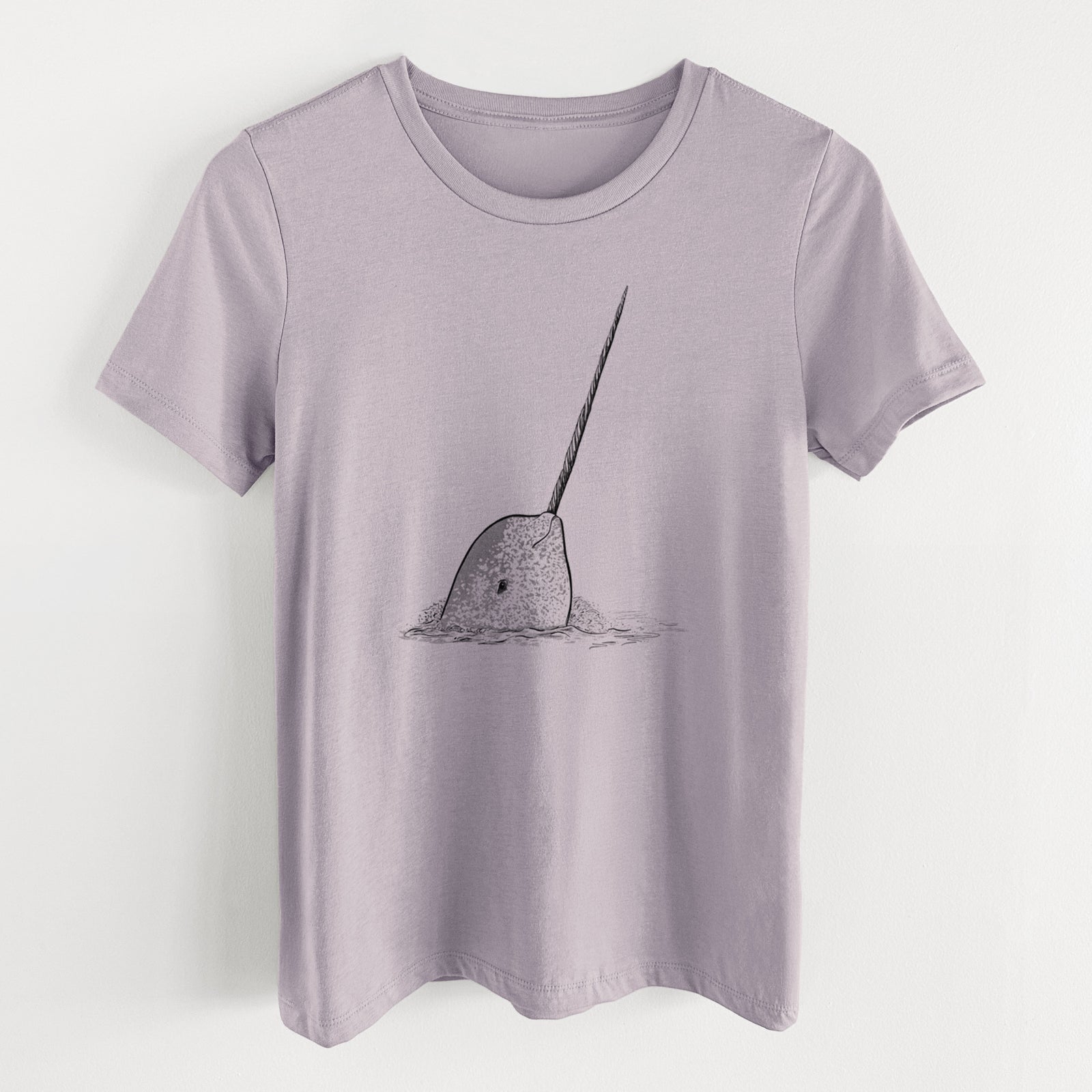 Light violet women's relaxed fit cotton t-shirt laid flat, printed with a black ink illustration of a narwhal with its long spiral tusk pointing upward.