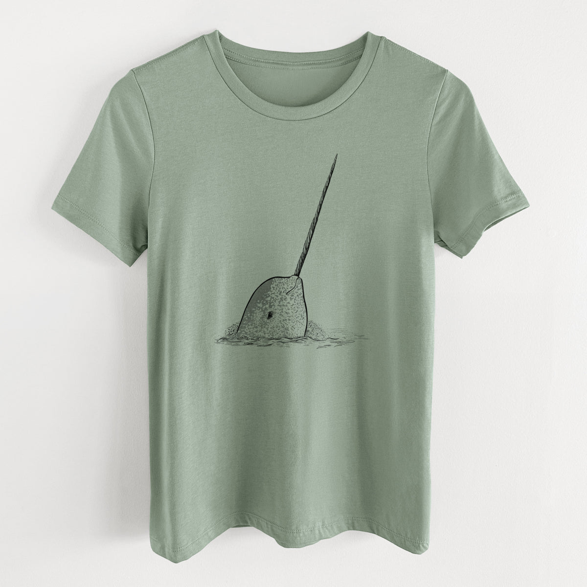 Sage green women's relaxed fit cotton t-shirt laid flat, printed with a black ink illustration of a narwhal with its long spiral tusk pointing upward.