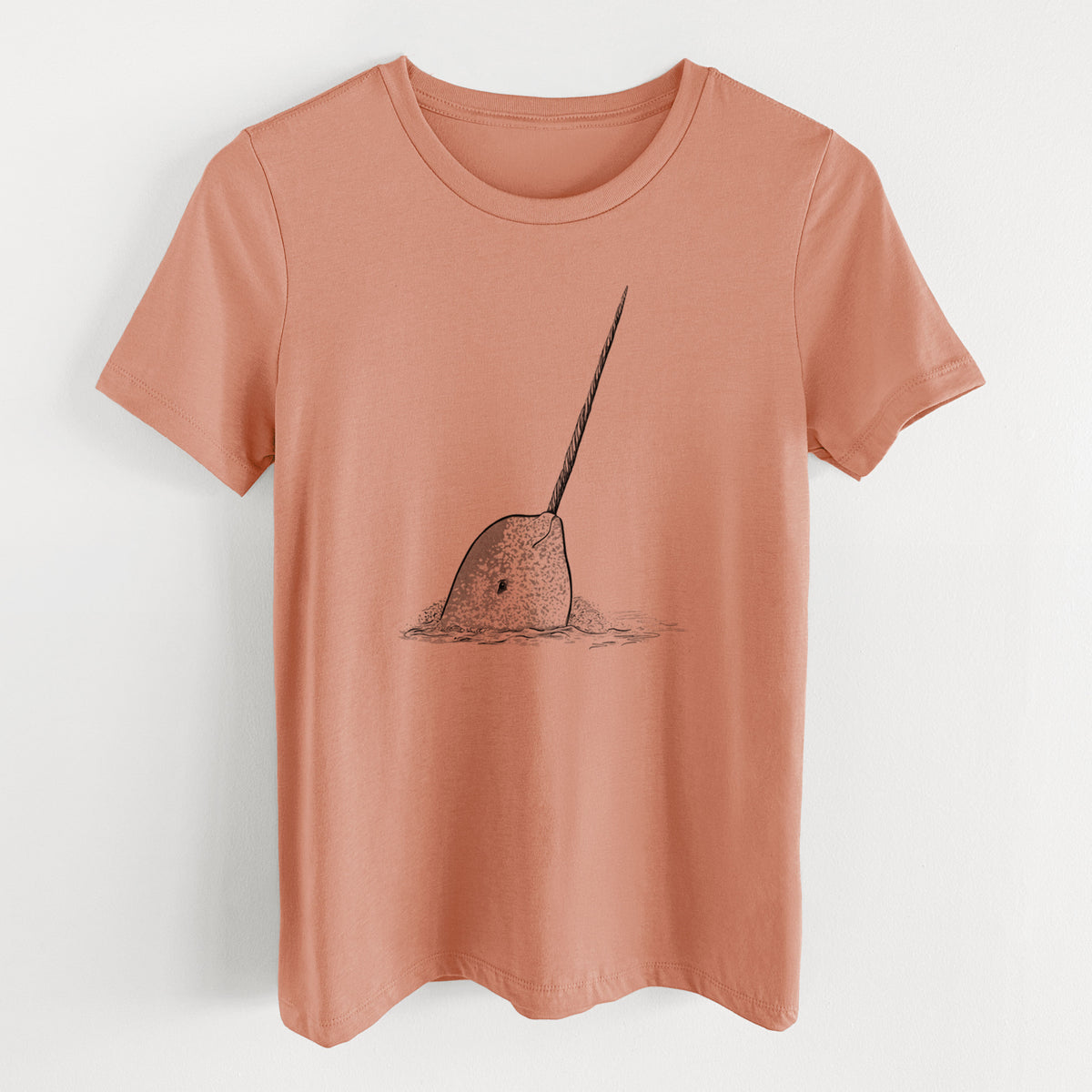 Terracotta orange women's relaxed fit cotton t-shirt laid flat, printed with a black ink illustration of a narwhal with its long spiral tusk pointing upward.