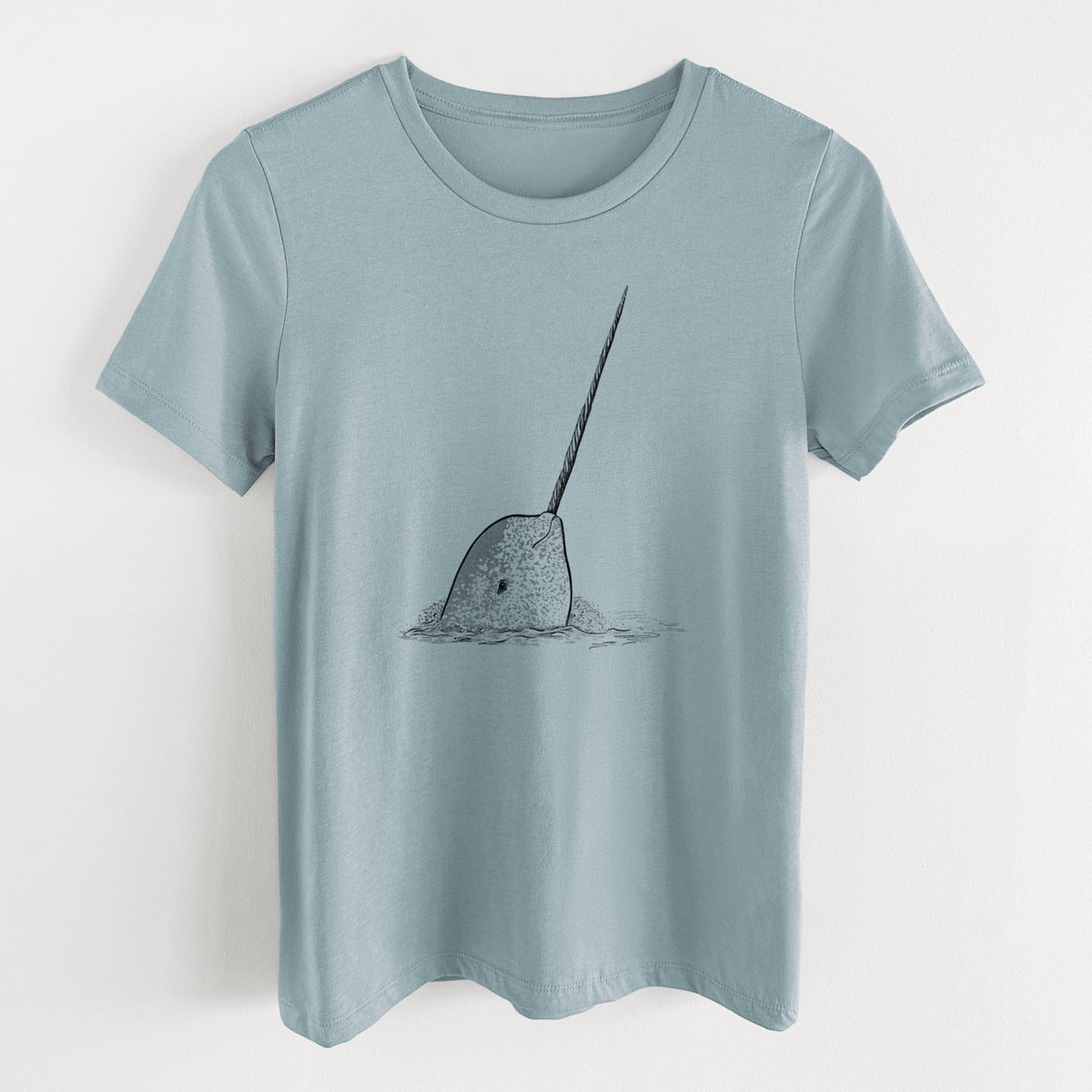 Vintage denim women's relaxed fit cotton t-shirt laid flat, printed with a black ink illustration of a narwhal with its long spiral tusk pointing upward.