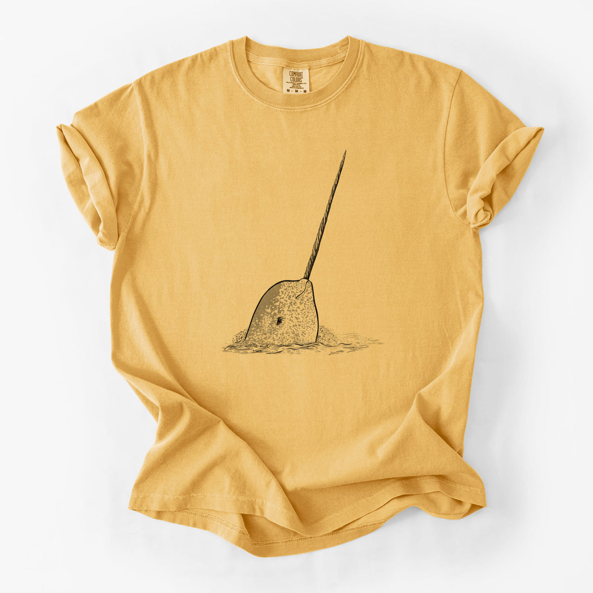Golden wheat yellow Comfort Colors t-shirt laid flat, printed with a black ink illustration of a narwhal with its long spiral tusk pointing upward.