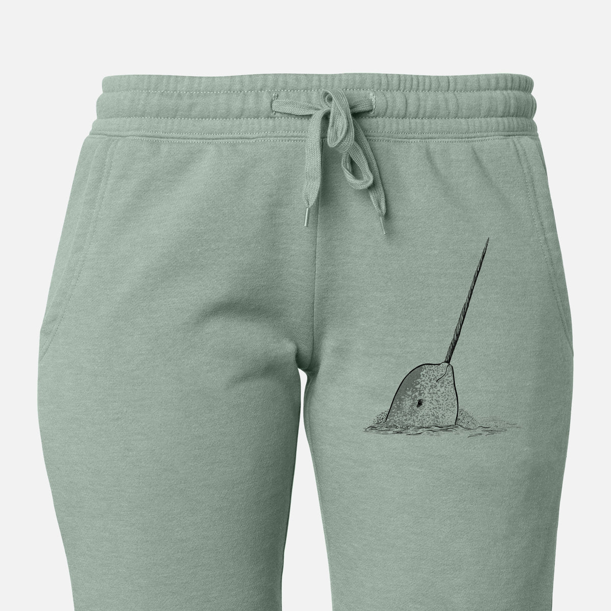 Front of sage green Cali Wave sweatpants, printed with a black ink illustration of a narwhal with its long spiral tusk pointing upward on the leg.