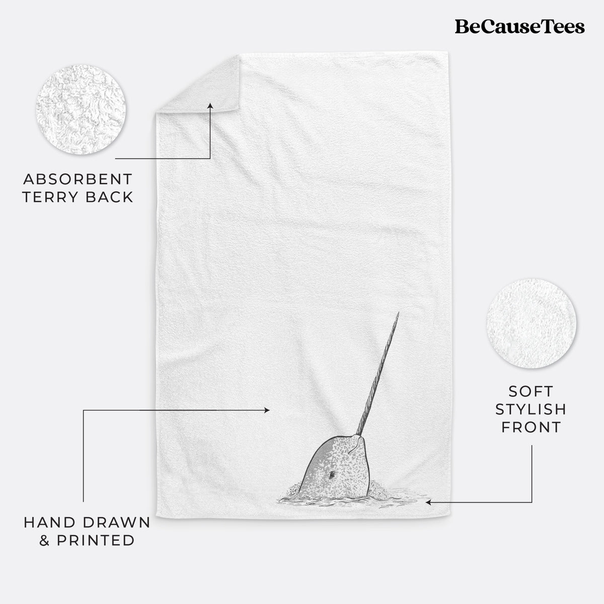 White hand towel printed with a black ink illustration of a narwhal with its long spiral tusk pointing upward.