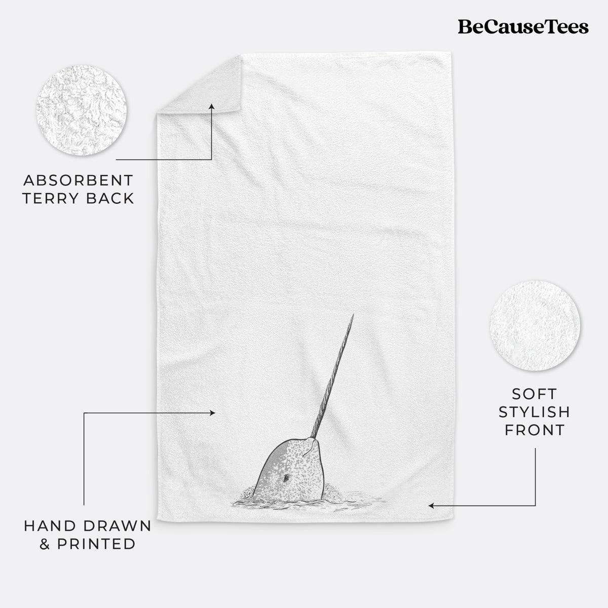 White hand towel printed with a black ink illustration of a narwhal with its long spiral tusk pointing upward.