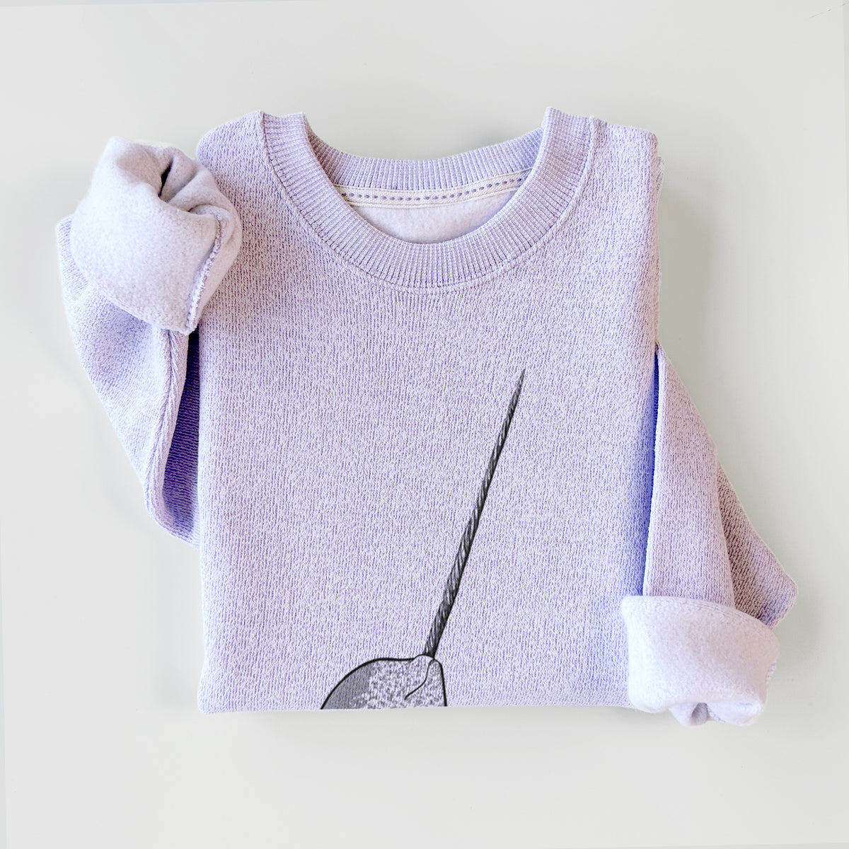 Ice purple knit sweatshirt printed with a black ink illustration of a narwhal with its long spiral tusk pointing upward, styled flat.