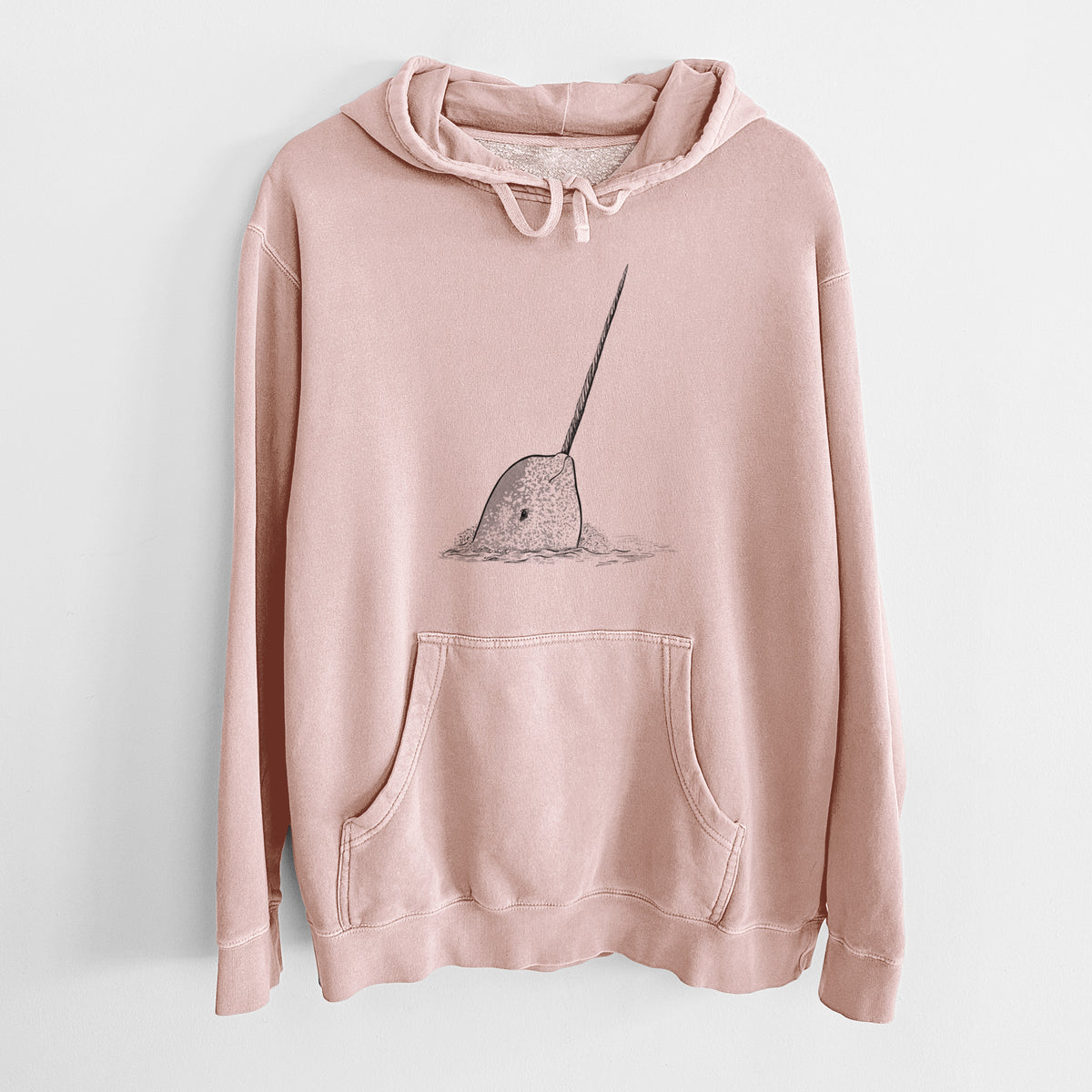 Dusty pink pigment dyed hoodie laid flat, printed with a black ink illustration of a narwhal with its long spiral tusk pointing upward.