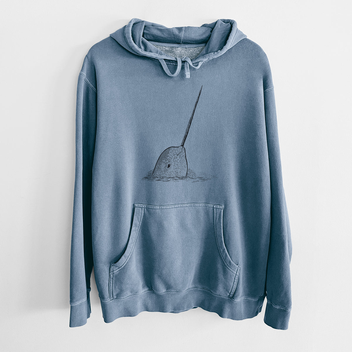 Slate blue pigment dyed hoodie laid flat, printed with a black ink illustration of a narwhal with its long spiral tusk pointing upward.
