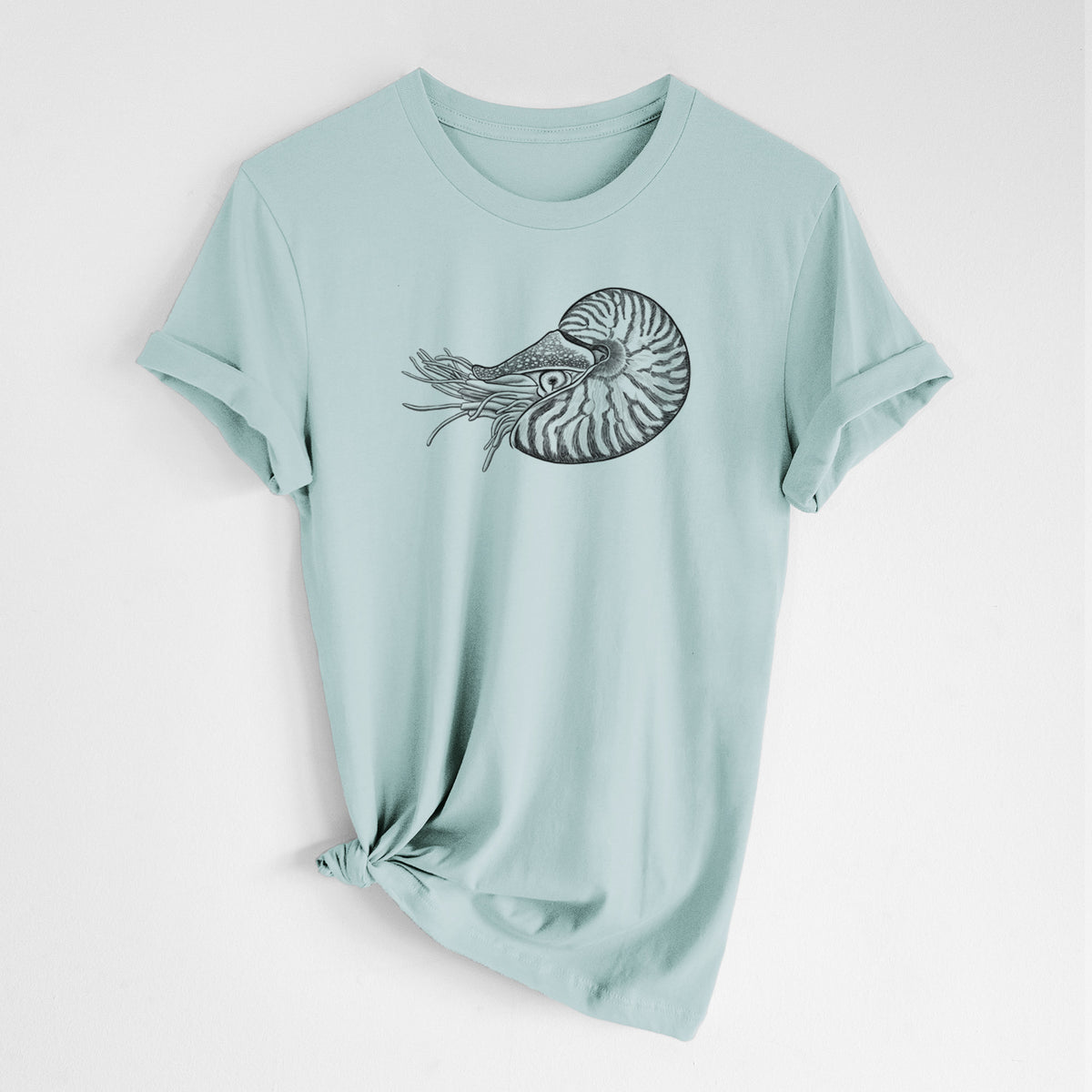 Dusty blue lightweight cotton t-shirt laid flat with the sleeves rolled, printed with a detailed black ink illustration of a chambered nautilus with its striped spiral shell and tentacles.