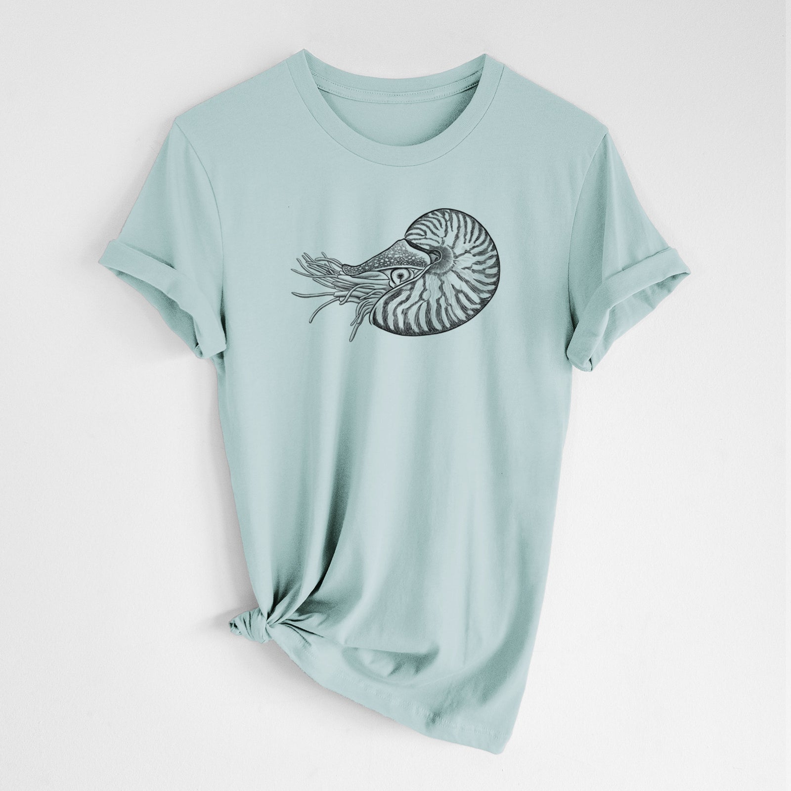 Sage green lightweight cotton t-shirt laid flat, printed with a detailed black ink illustration of a chambered nautilus with its striped spiral shell and tentacles.