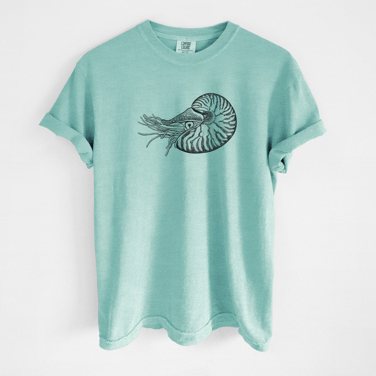 Chalky mint Comfort Colors t-shirt laid flat, printed with a detailed black ink illustration of a chambered nautilus with its striped spiral shell and tentacles.