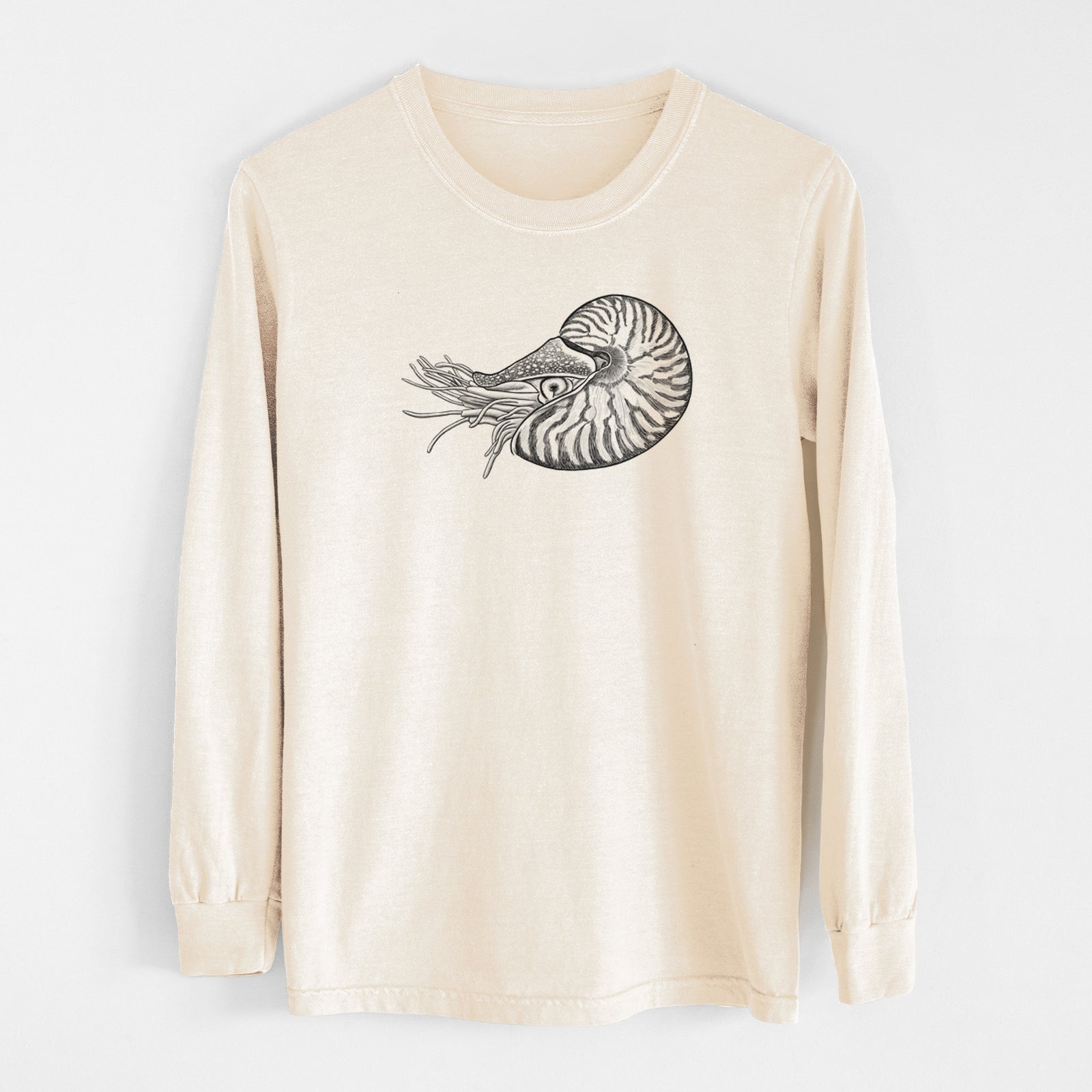 Ivory Comfort Colors long sleeve shirt laid flat, printed with a detailed black ink illustration of a chambered nautilus with its striped spiral shell and tentacles.