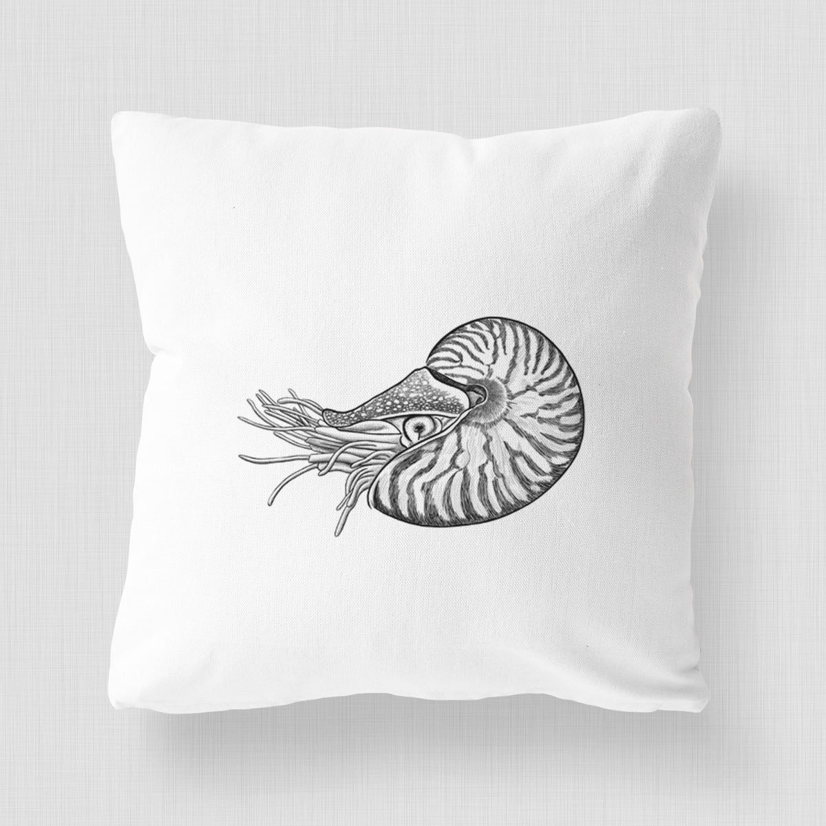 White pillow cover printed with a detailed black ink illustration of a chambered nautilus with its striped spiral shell and tentacles.