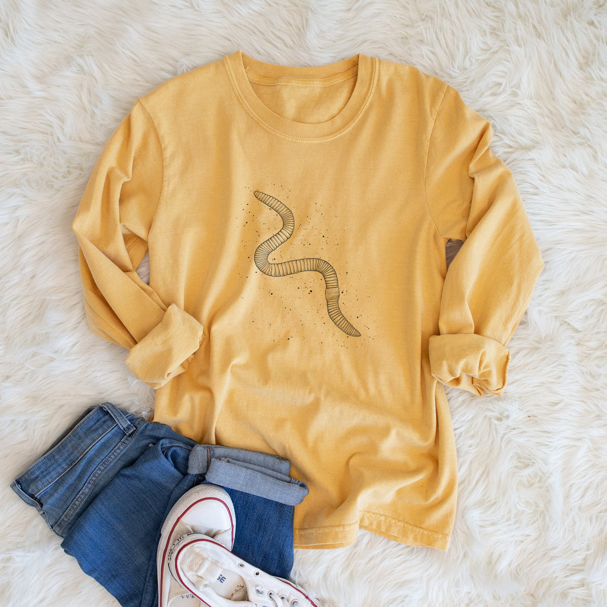 Golden wheat yellow Comfort Colors long sleeve shirt printed with a black ink illustration of a nightcrawler earthworm with soil specks, shown in a lifestyle photo.